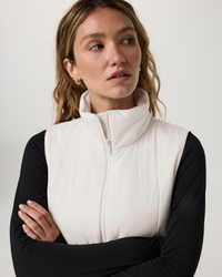 Women's sleeveless puffer vest in off-white with zip front and mock neck, detail view