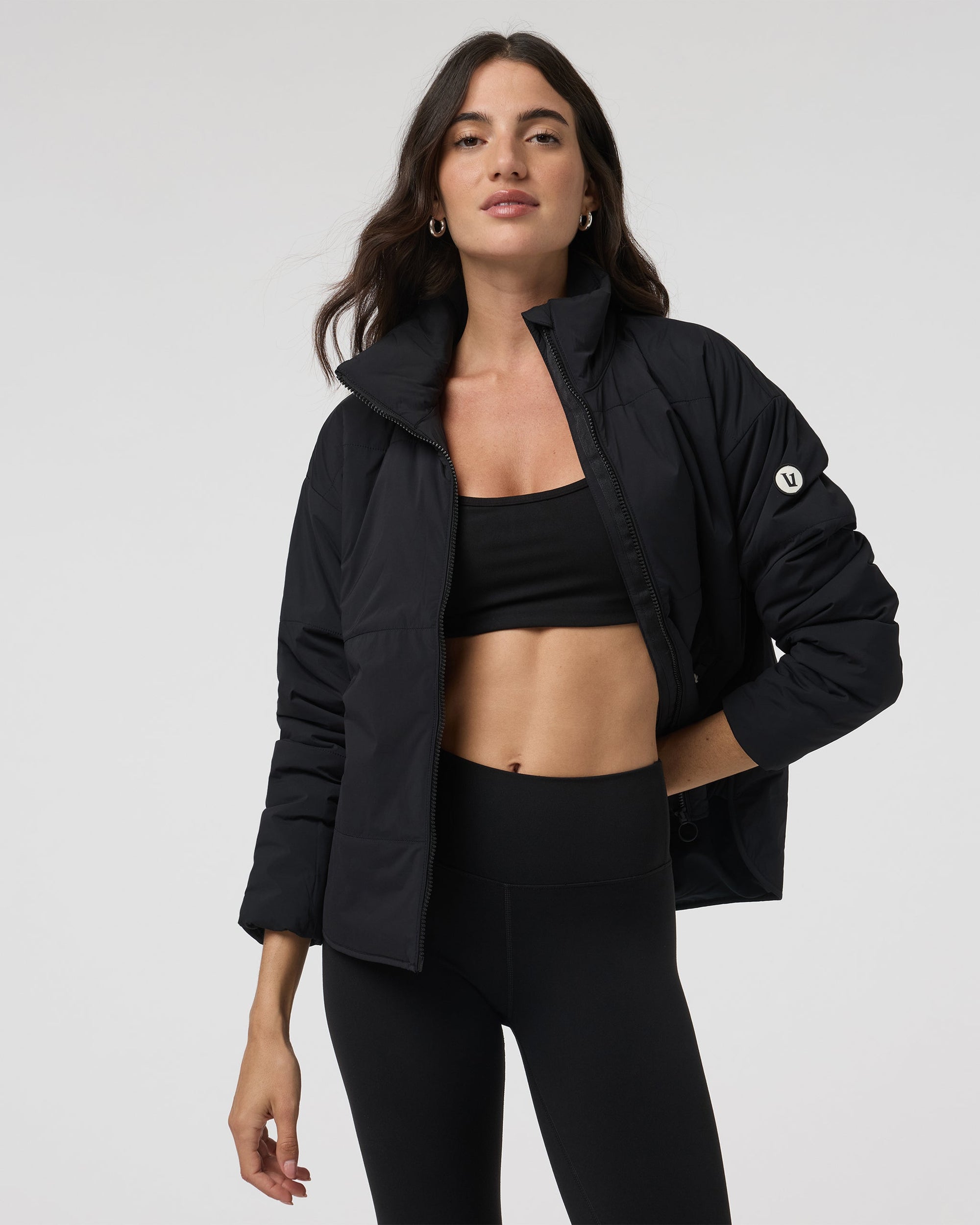 Women's black insulated puffer jacket open front view with stand collar, on model