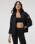 Women's black insulated puffer jacket open front view with stand collar, on model