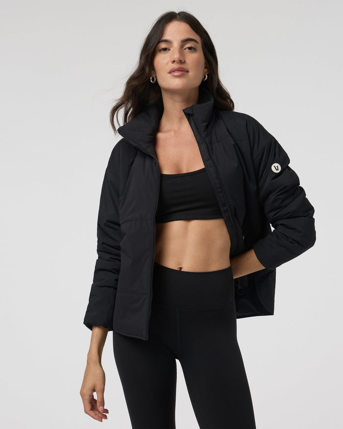 Women's black insulated puffer jacket open front view with stand collar, on model