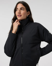Black insulated zip-up jacket with high collar, detail close-up on model