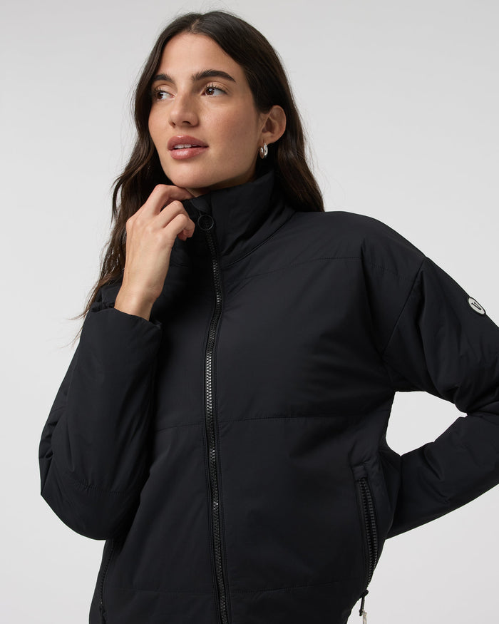 Black insulated zip-up jacket with high collar, detail close-up on model
