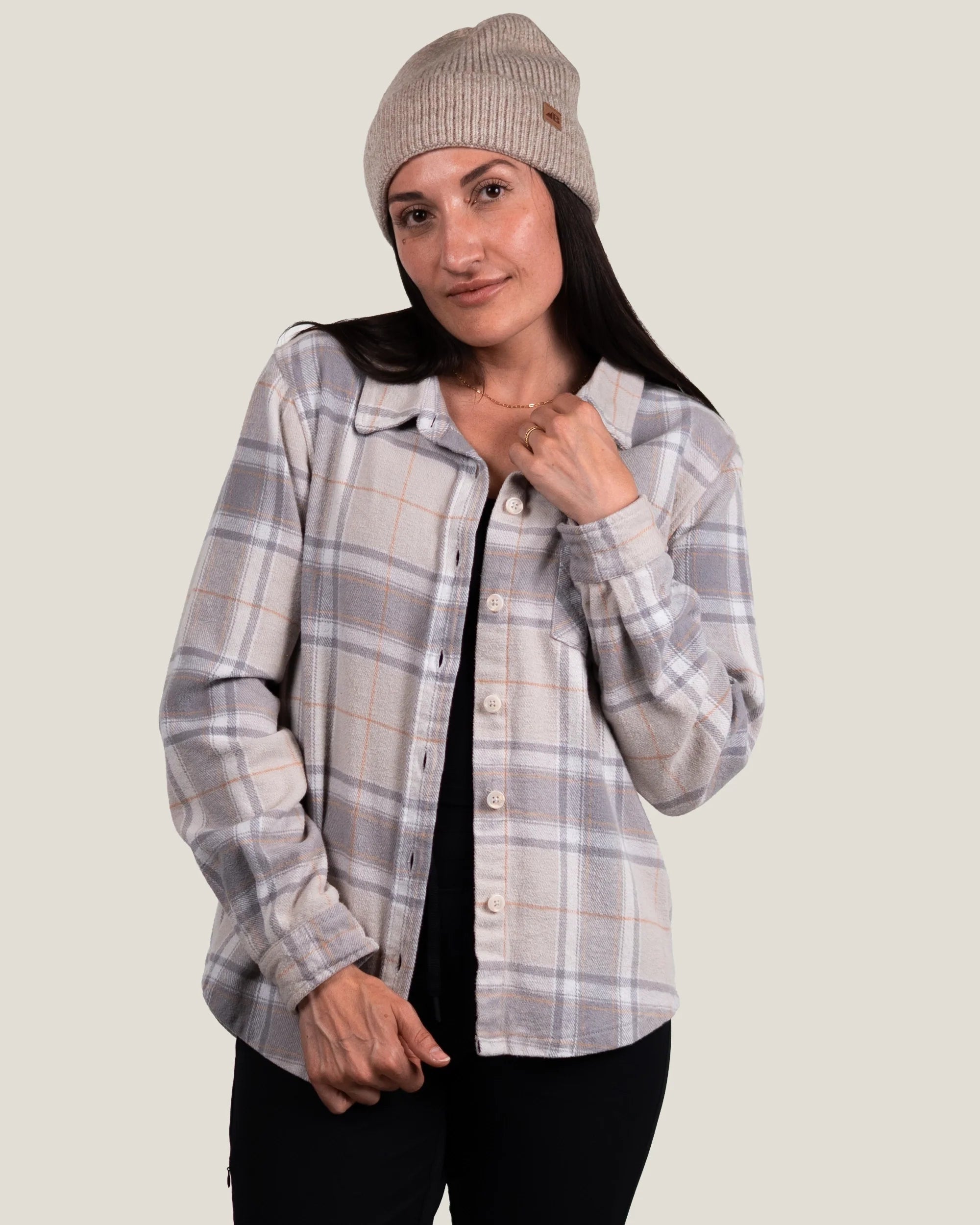 Women's plaid flannel shirt in light gray tones, open over black top, front model view