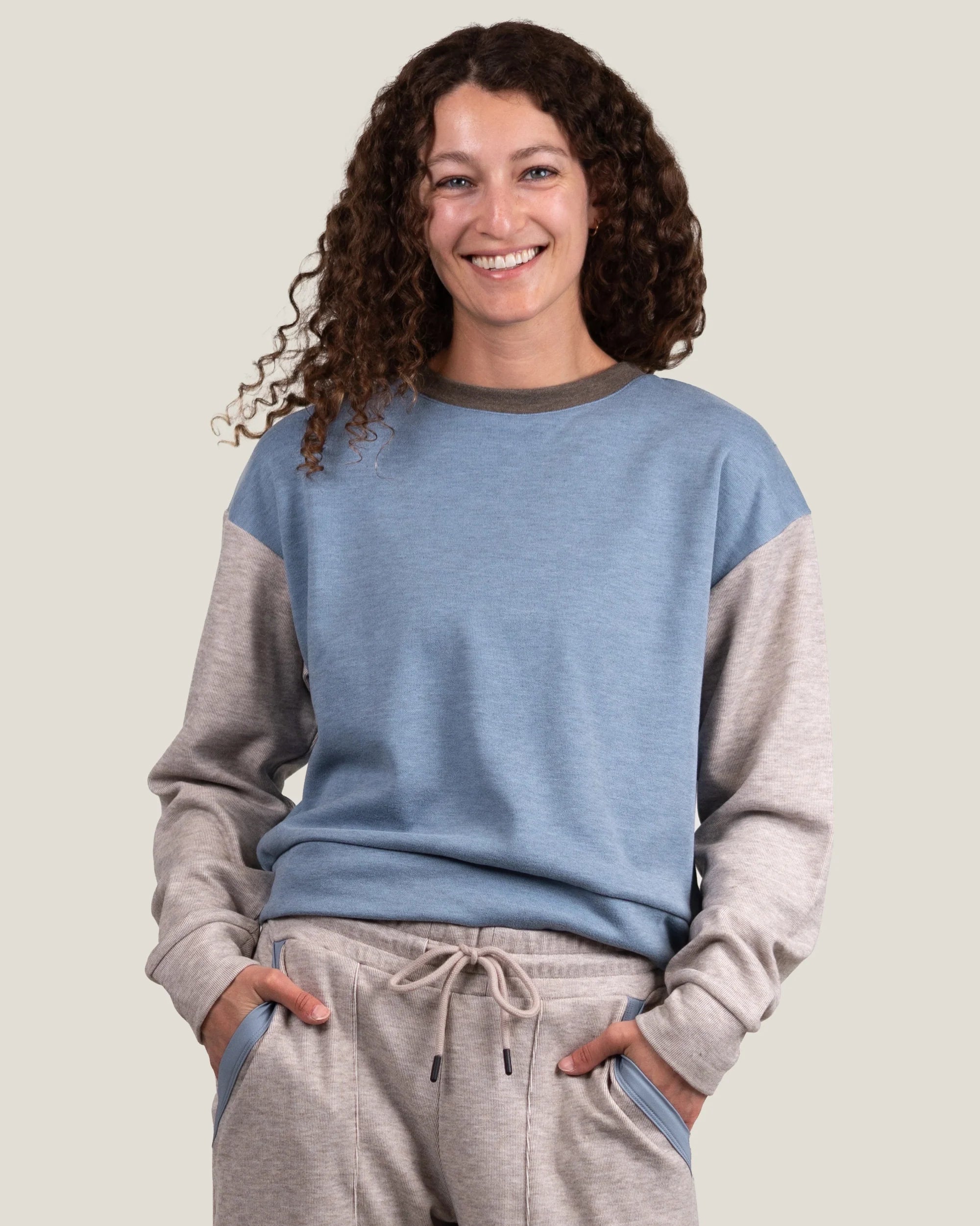 Women's colorblock fleece crewneck sweatshirt with blue front panel and gray sleeves, front view on model