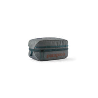 Small rectangular travel cube organizer with teal zipper and logo, angled three-quarter view