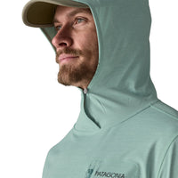 Sage green sun protection hoody with integrated cap visor and hood up, profile view