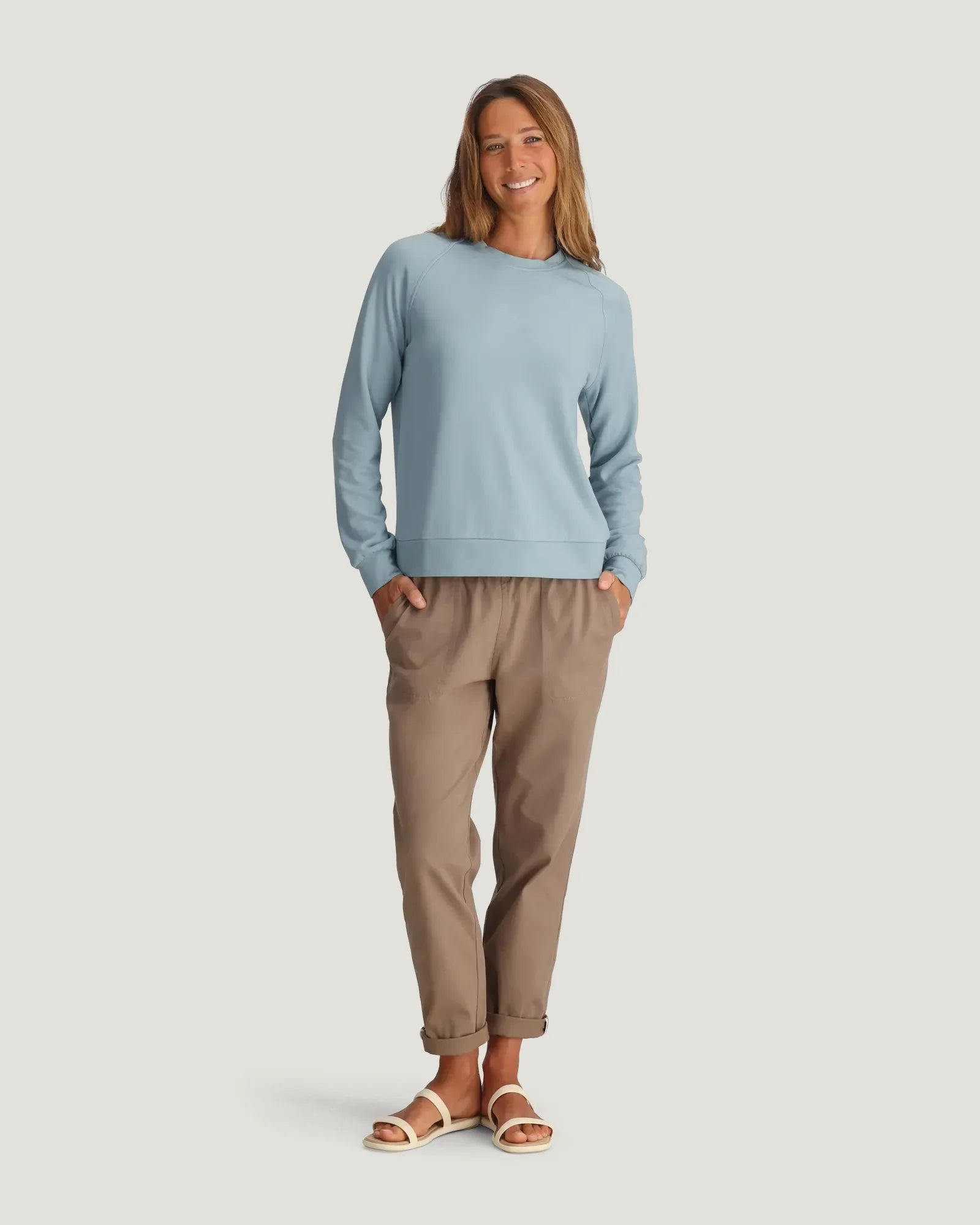 Women's light blue crewneck fleece pullover with raglan sleeves, full front view on model