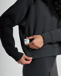 Black fleece crew sweatshirt with ribbed cuffs and hem, hands in front pocket