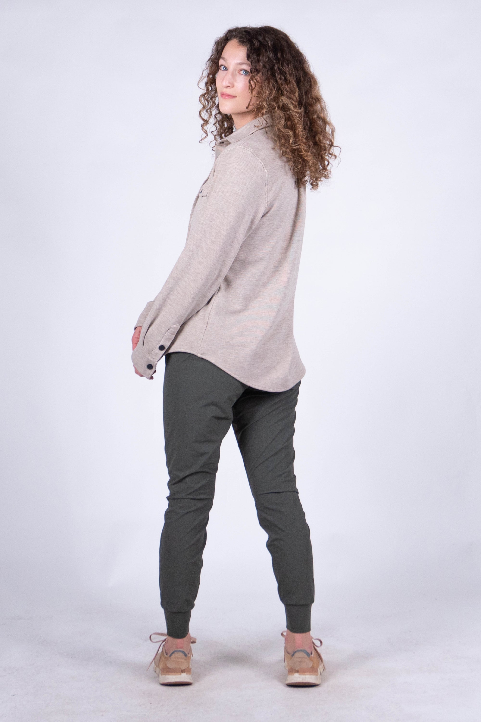 Women's fleece button-up shirt in light oatmeal, back view, with dark olive jogger pants