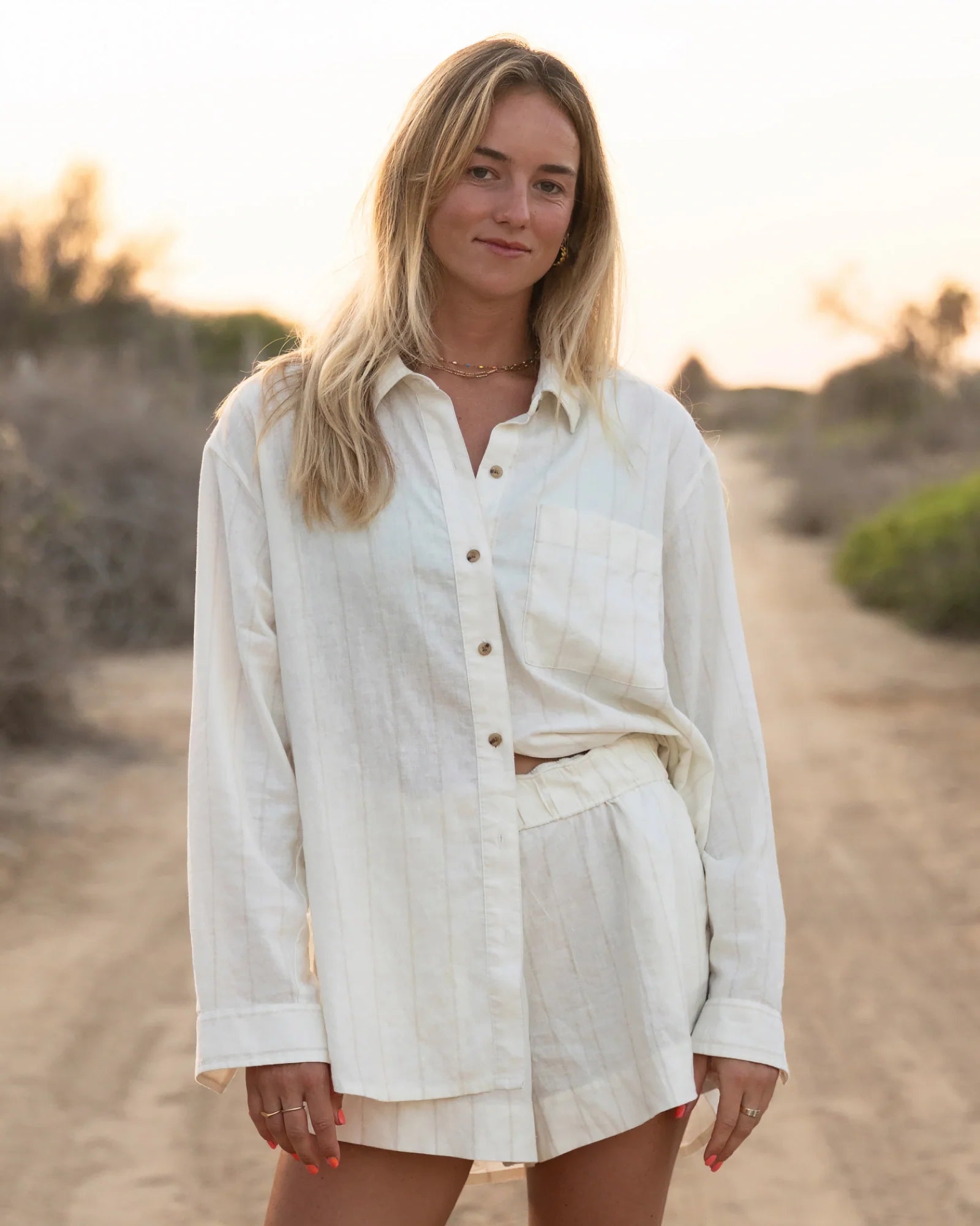 Light colored linen shorts set with button-up shirt, worn in outdoor lifestyle setting