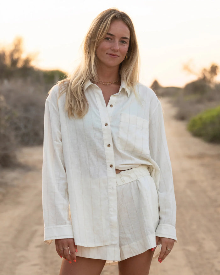 Light colored linen shorts set with button-up shirt, worn in outdoor lifestyle setting