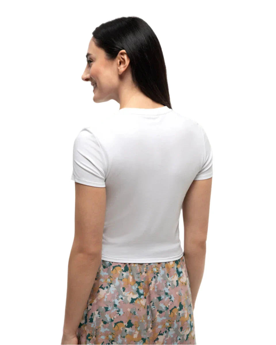 White short-sleeve fitted t-shirt shown from back angle on model with floral skirt