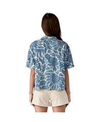 Blue and white botanical print short-sleeve shirt shown from back view with beige shorts