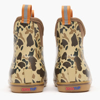 Pair of ankle-height rubber boots with camouflage pattern, orange pull tabs, and gum sole, rear view