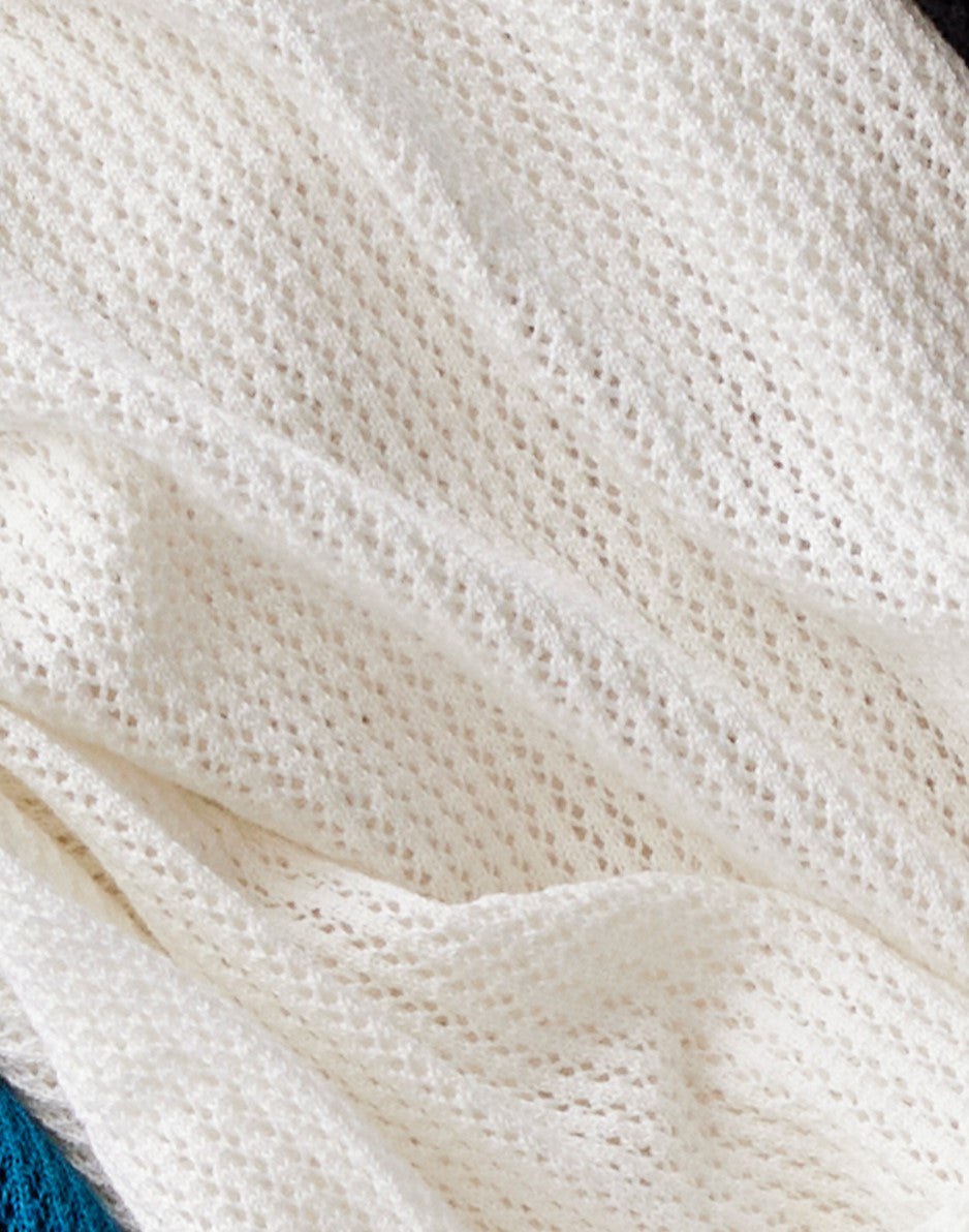 Cream colored mesh pullover with textured knit pattern laid flat