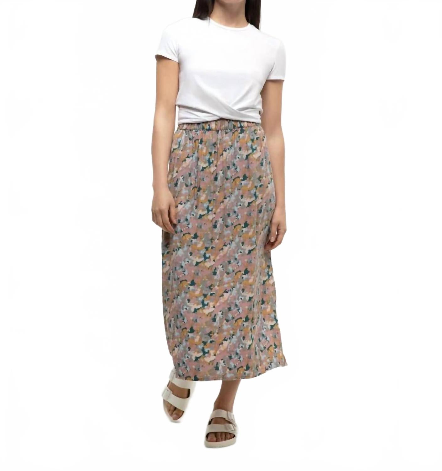 Long midi skirt with abstract floral pattern, worn with white twisted tee and sandals