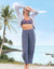 Wide-leg linen pants in speckled blue pattern worn by woman on tropical beach