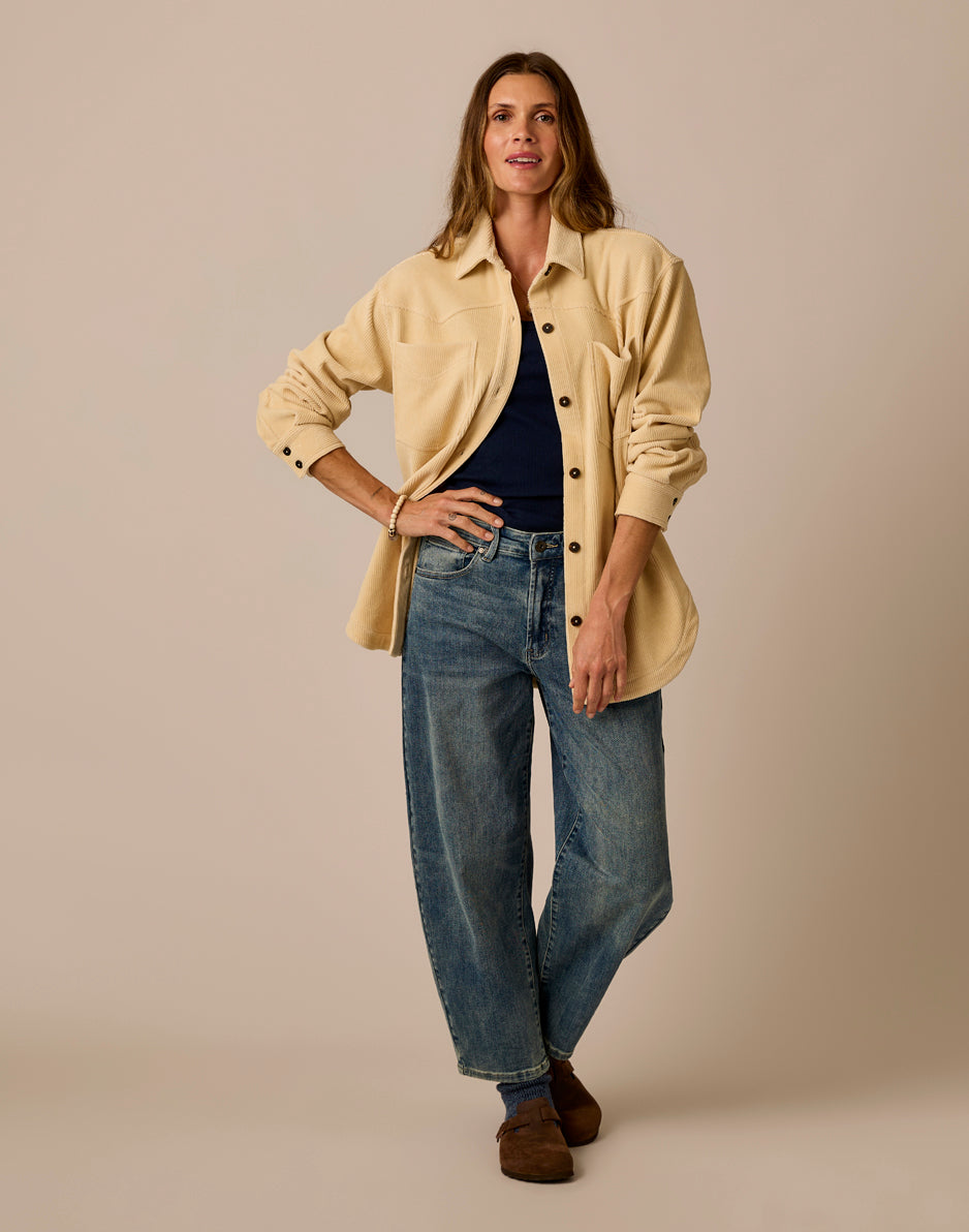 Women's oversized button-front shacket in cream, worn open over navy top with jeans, front view