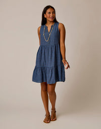 Sleeveless tiered midi dress with v-neck and small dotted pattern worn with layered necklace
