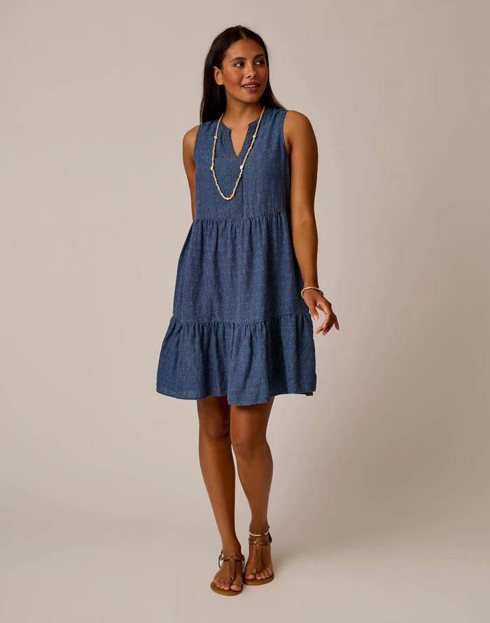 Sleeveless tiered midi dress with v-neck and small dotted pattern worn with layered necklace