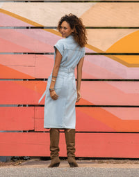 Women's sleeveless denim midi dress with belt and back pockets, back view on model