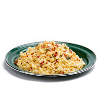 Prepared fettuccine pasta dish with creamy sauce, herbs and vegetables on green plate