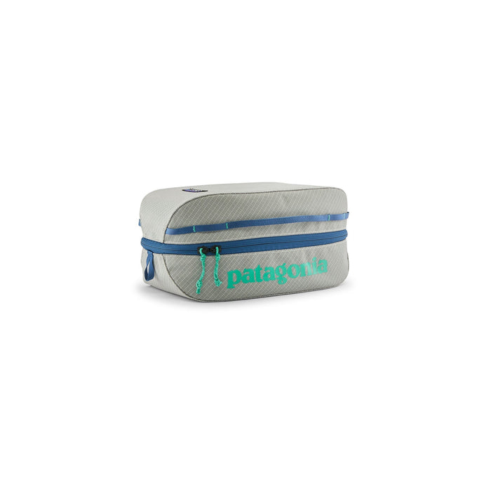 Compact rectangular travel cube bag with blue zipper and teal logo, three-quarter view