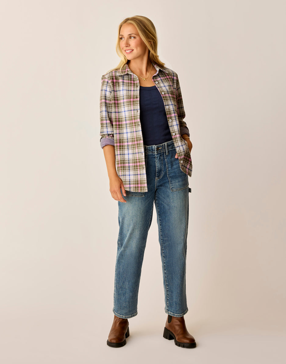 Women's plaid flannel shirt worn open over navy tank top with jeans, front view