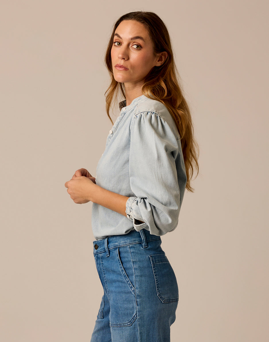 Women's lightweight denim blouse with puff sleeves and tie cuffs, side view on model