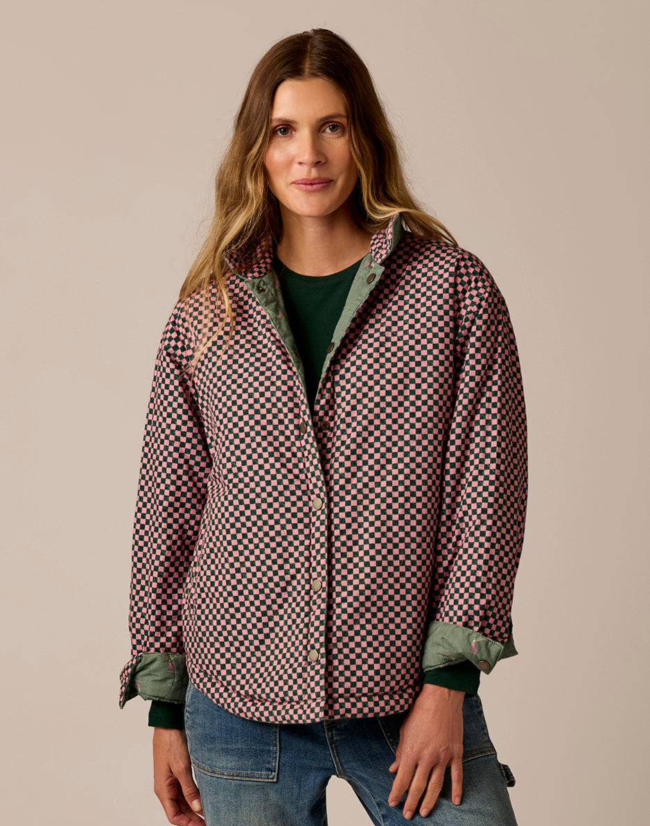 Women's reversible jacket in pink and dark checkerboard pattern with green lining, front view