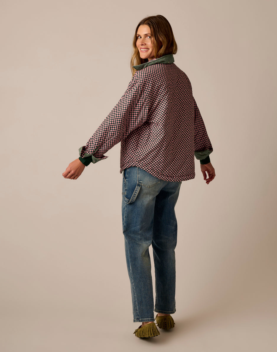 Reversible quilted jacket in checkered pattern with green collar, back view on model with jeans