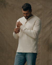 Men's long-sleeve waffle knit henley in cream, on-model front view with buttons visible