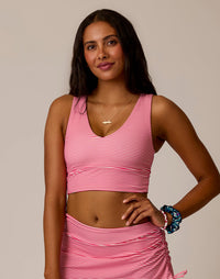 Women's striped pink and white crop tank top with V-neckline, front view on model