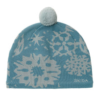 Knit beanie with snowflake pattern in blue and grey, topped with a fluffy pom-pom