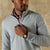 Light grey quarter-zip pullover with textured fabric worn over plaid shirt