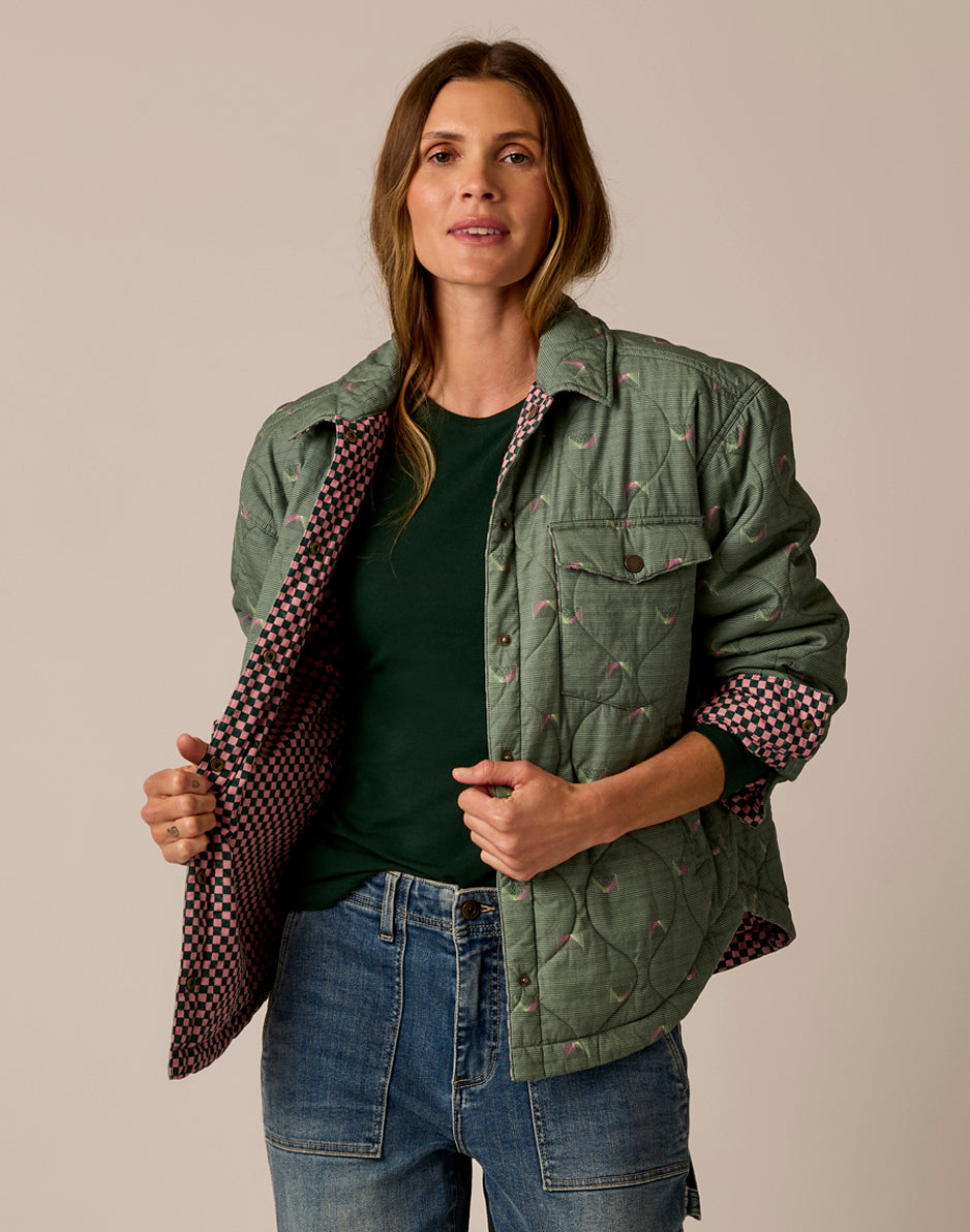 Women's reversible quilted shirt jacket in sage green with pink checkered lining, open front view