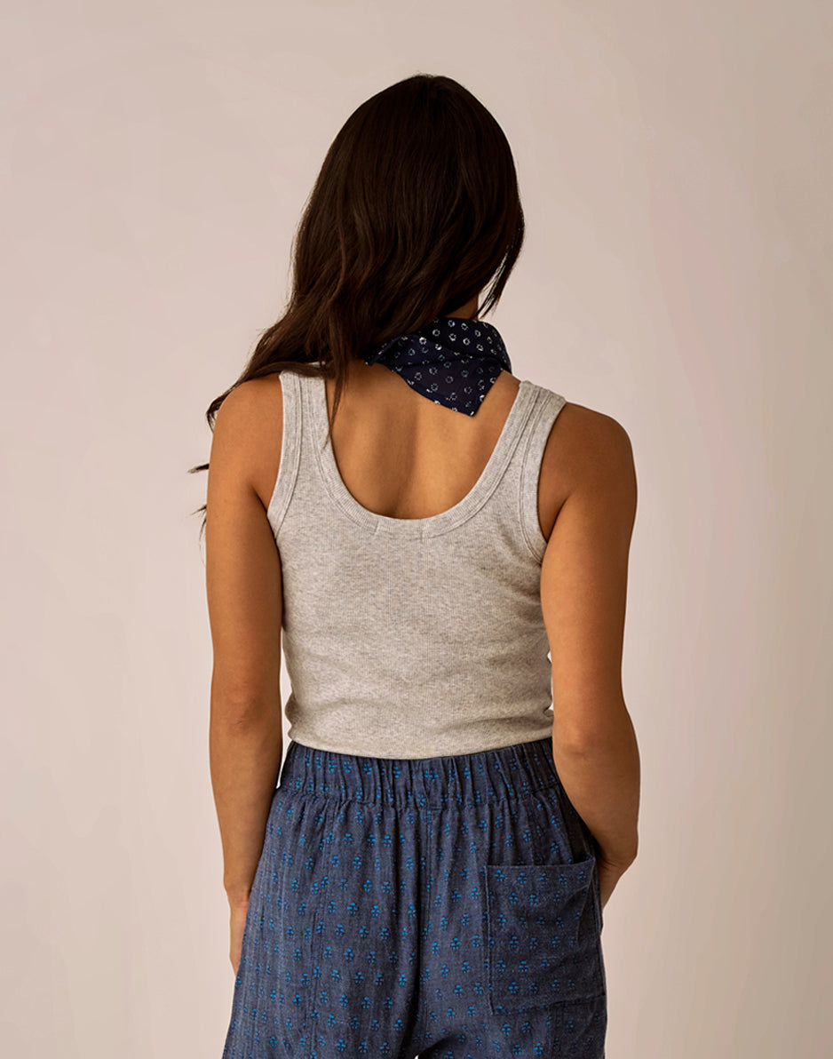 Grey ribbed tank top shown from back, worn with patterned shorts and bandana