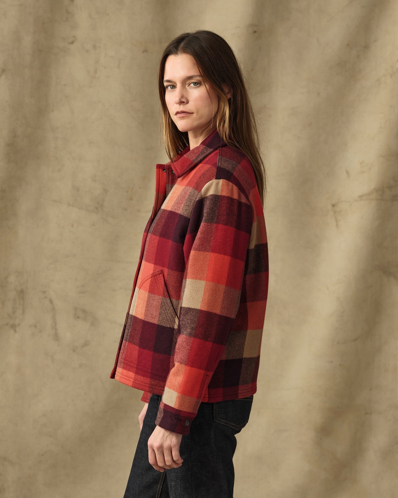 Women's plaid insulated jacket in red and burgundy check, side view on model