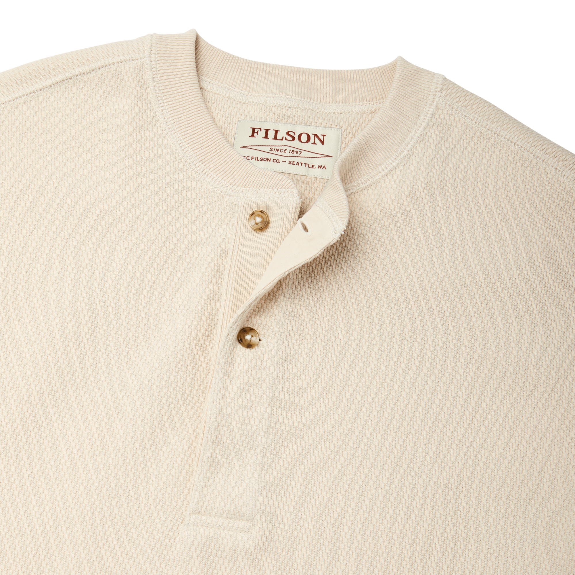 Close-up of cream waffle knit henley with brass buttons and ribbed collar, detail view