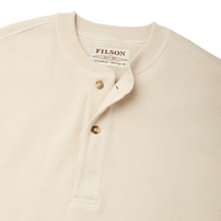 Close-up of cream waffle knit henley with brass buttons and ribbed collar, detail view