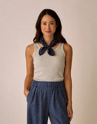 Light grey ribbed sleeveless tank top worn with blue patterned pants and scarf