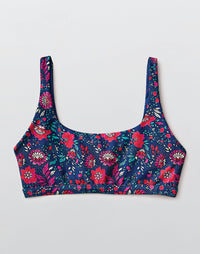 Women's compression sports bra with vibrant floral pattern on navy background, front view