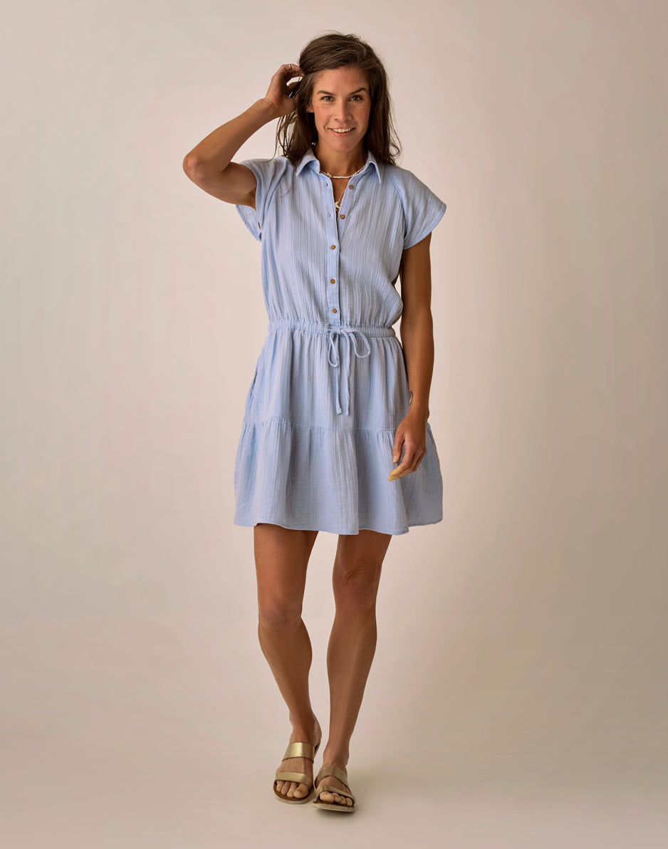 Light blue short-sleeve dress with button front, drawstring waist, and tiered skirt on model