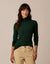 Women's fitted long-sleeve turtleneck in dark green, front view on model with khaki pants