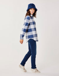 Women's oversized plaid button-up shirt in navy and white check, side view on model