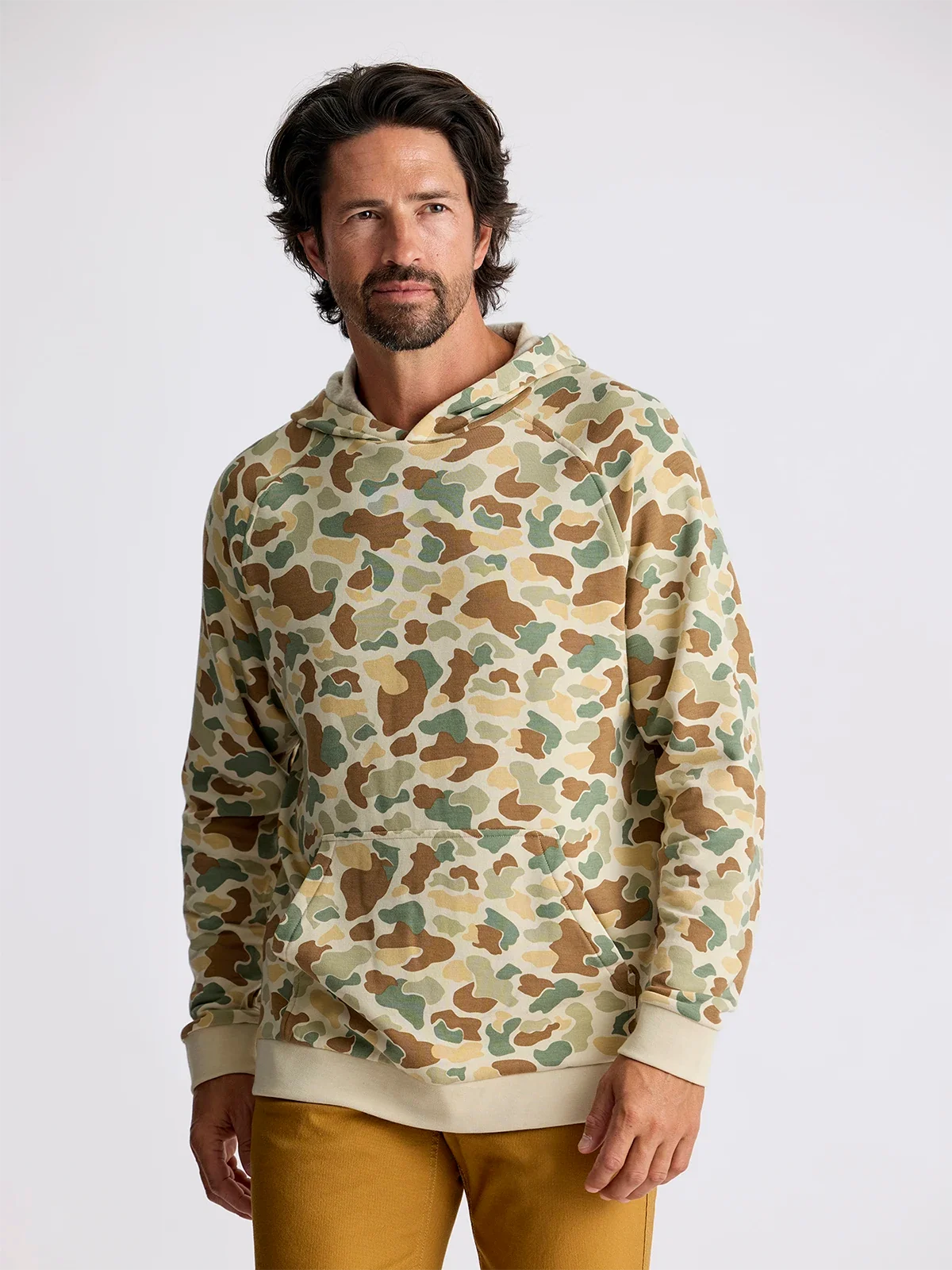 Men's camouflage pullover hoodie with kangaroo pocket, front view on model