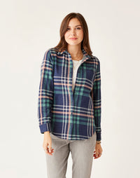 Women's plaid flannel button-up shirt in navy and green tartan, front view on model