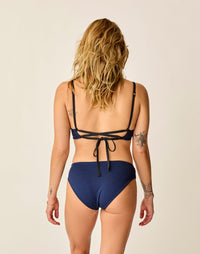 Women's reversible bikini bottom in navy blue, back view, with strappy black tie top