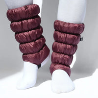 Quilted puffer leg gaiters in deep burgundy, covering lower legs over white socks, front view
