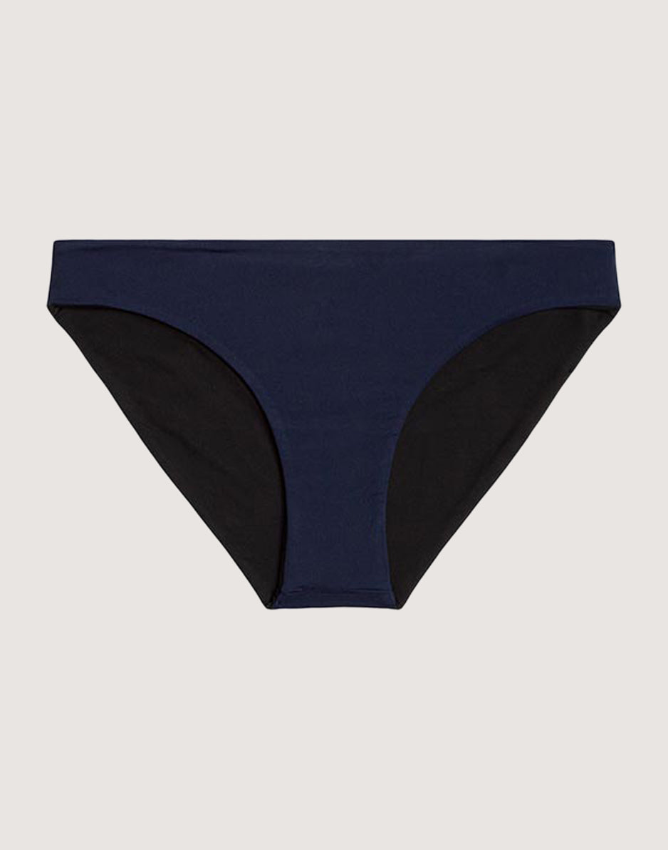 Reversible bikini bottom with navy blue front panel and black side panels, flat lay view